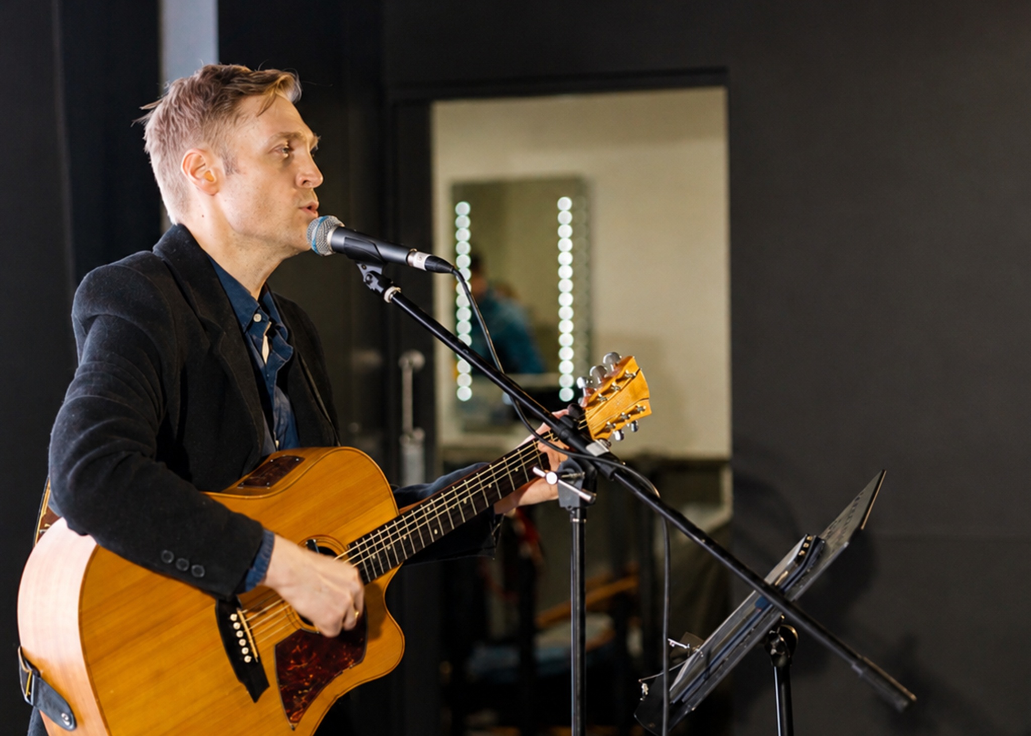 Robert Rosina performing live with acoustic guitar and microphone